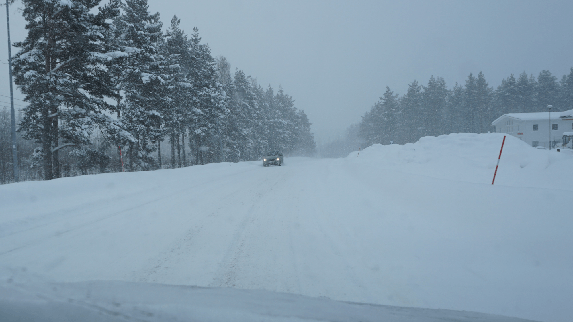Bild på landsväg under vinterväglag där plogpinnar är uppsatta vid vägrenen.