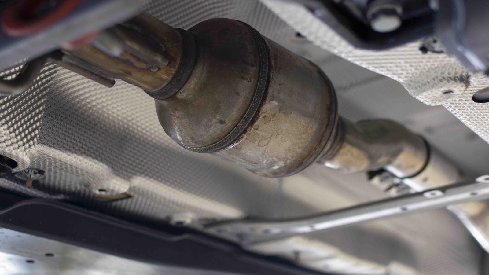 Bild på en katalysator som sitter under en bil.