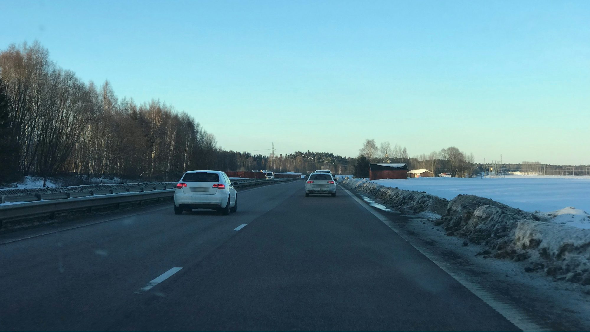 Motorväg där det är två bilar körandes. En i vänster fil och en i höger fil.